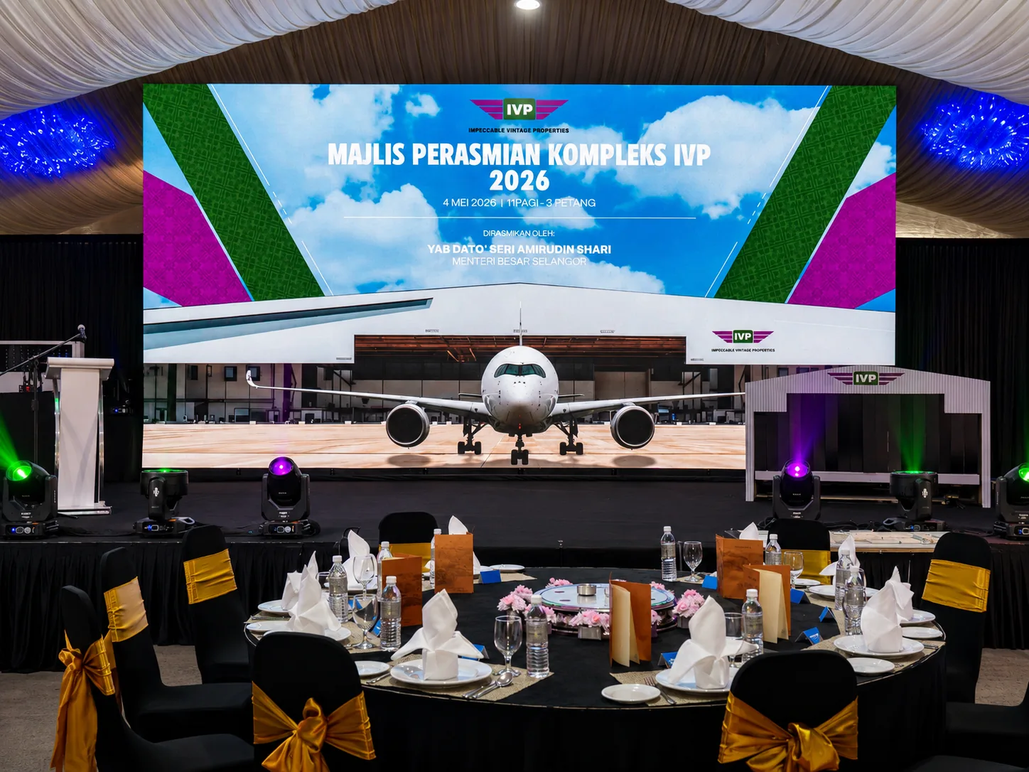 IVP Majlis Perasmian Kompleks 2026 – wide banquet hall with large LED screen showing jet on runway